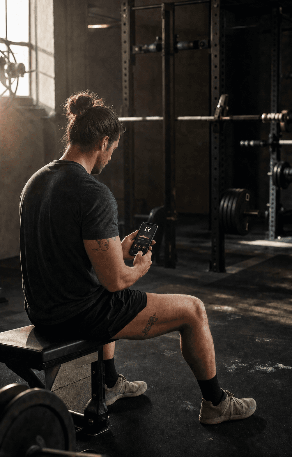 Strength athlete using the Long Road Fitness app between sets